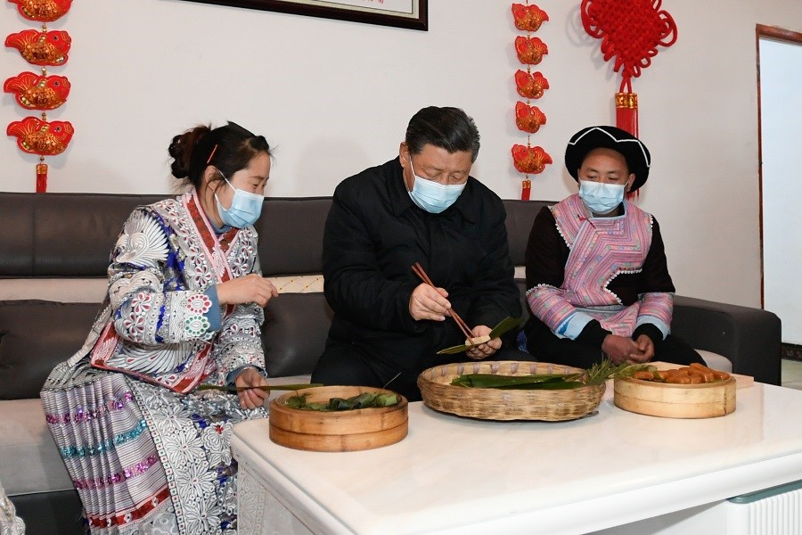 2021年2月3日下午，習(xí)近平在貴州畢節(jié)市黔西縣新仁苗族鄉(xiāng)化屋村苗族村民趙玉學(xué)家，同一家人邊聊家常邊制作當(dāng)?shù)貍鹘y(tǒng)節(jié)日食品黃粑。新華社記者 李學(xué)仁 攝